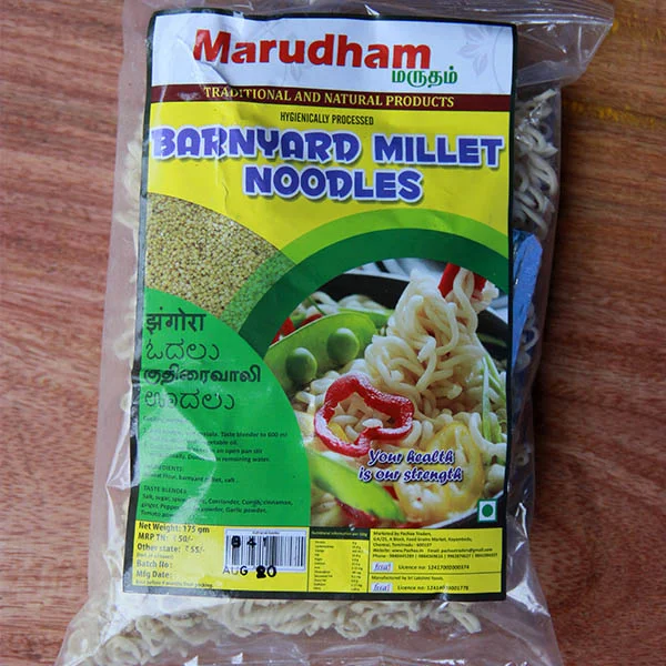 Kuthiraivali_noodles A plastic package of Barnyard Millet Noodles, featuring a bright yellow label with the brand name "Marudham" at the top, images of cooked noodles with vegetables, and text in multiple languages.