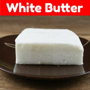 A block of white butter placed on a brown plate, with a red banner above it displaying the text "White Butter."