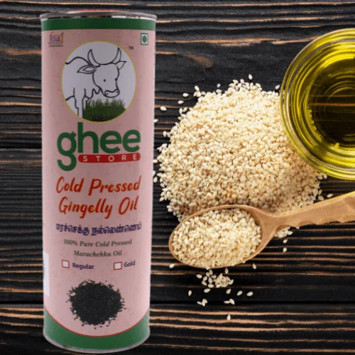 A canister of cold-pressed gingelly oil next to scattered sesame seeds and a wooden spoon filled with sesame seeds, with a small bottle of oil in the background.